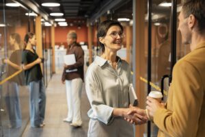 Onboarding de colaboradores em ambiente corporativo com aperto de mãos entre profissionais