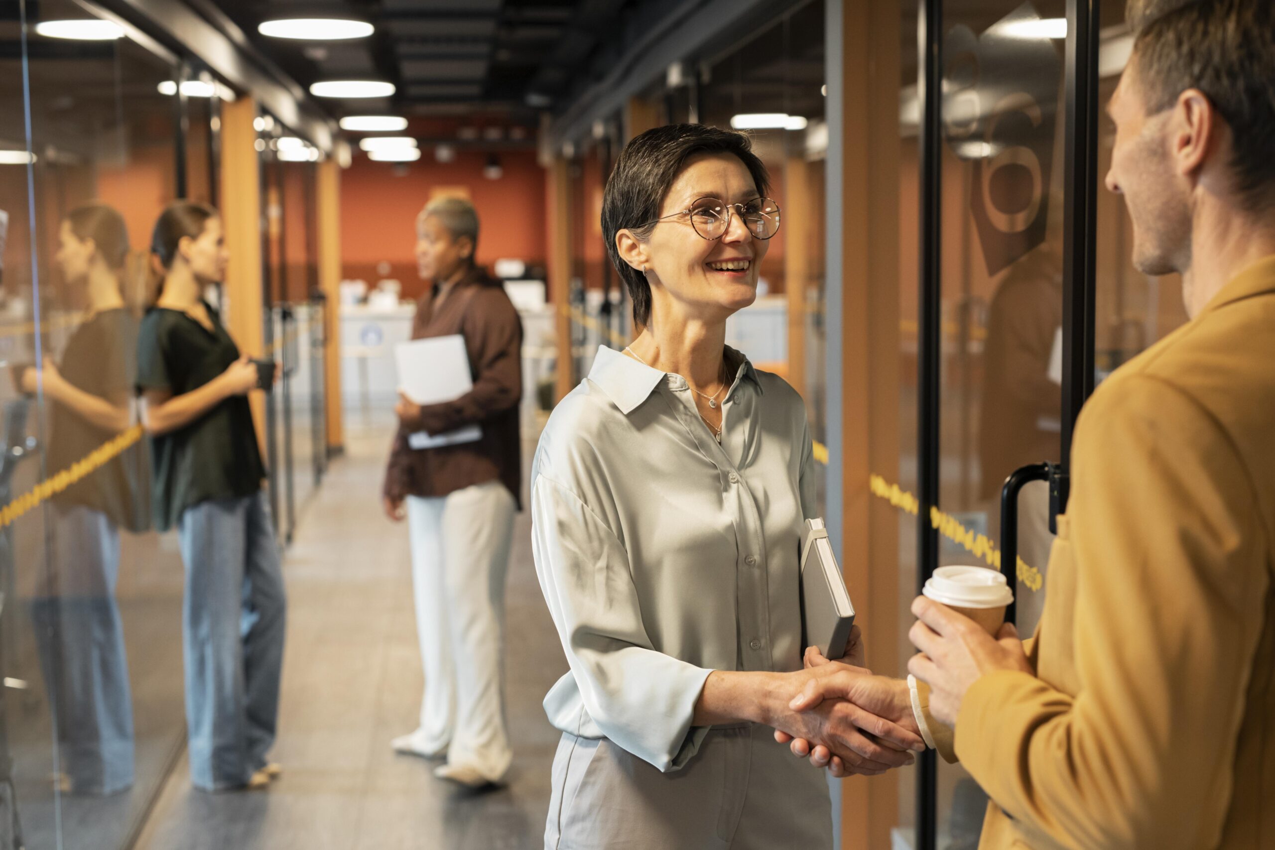 Onboarding de colaboradores em ambiente corporativo com aperto de mãos entre profissionais